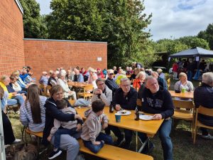 Besucher des Sommerfestes 2026 an Biergarten-Tischen auf dem Gelände der Feuerwehr